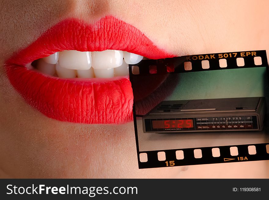 Person Wearing Red Lipstick Biting Film