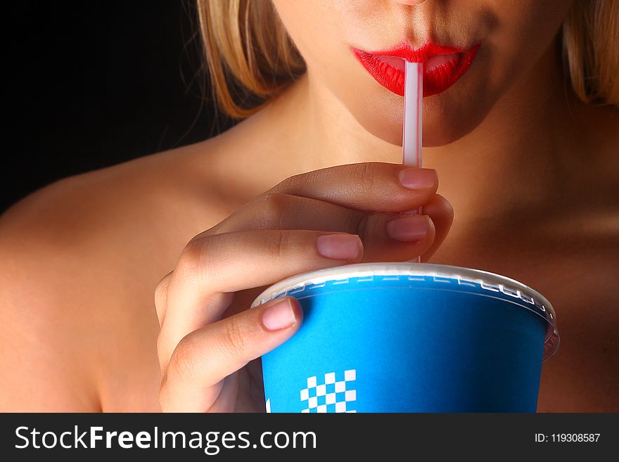 Woman Holding Blue And White Disposable Cup In Closeup Photography