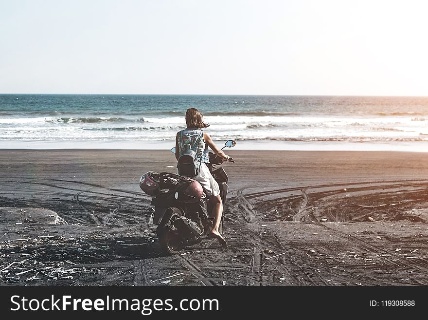 Woman Riding Motor Scooter on Seashore