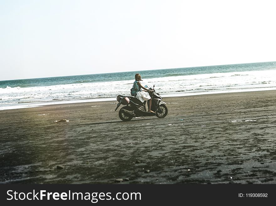 Man Riding Black and Gray Motor Scooter on Beach