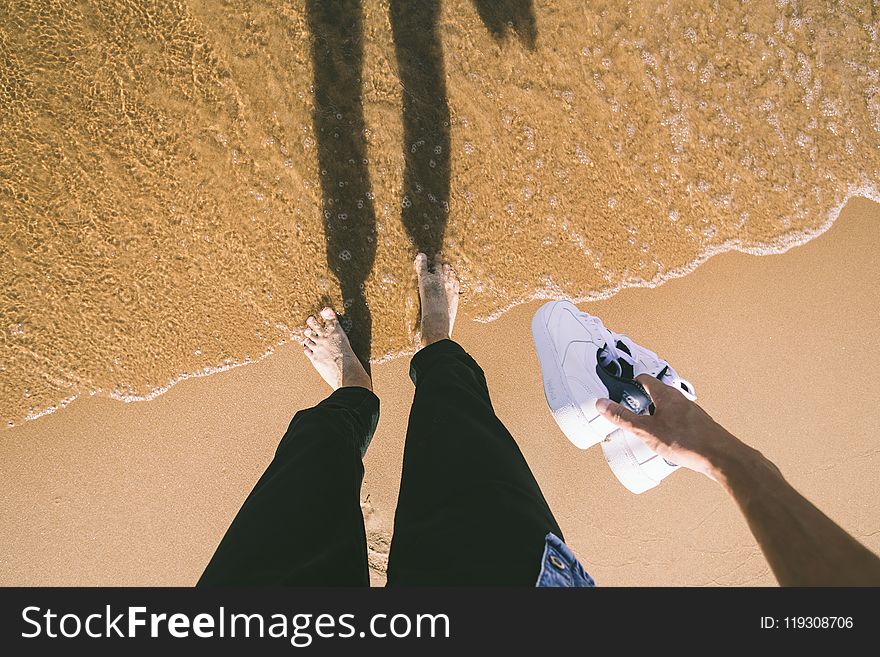 Photo of Person Holding Sneakers