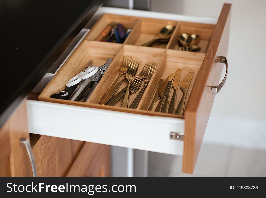 Silver-colored Cutlery Set on Brown Wooden Dresser