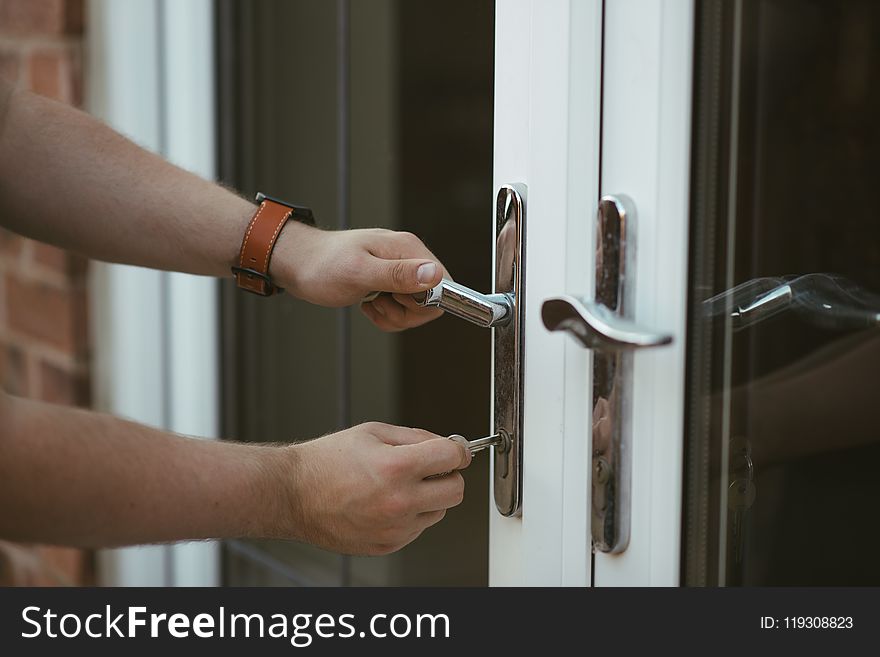 Person Holding Door Lever and Key