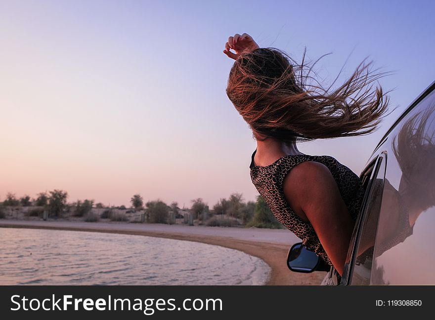 Woman With Brown Hair In Car During Sunset