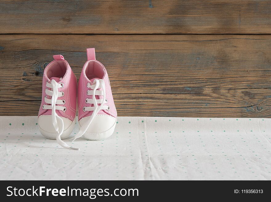 Cute little baby shoes on green polka dot background, top view. Cute little baby shoes on green polka dot background, top view