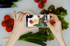 Food Blogger Concept. Hands With The Phone Close-up Pictures Of Food. Royalty Free Stock Images