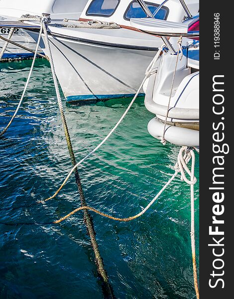 View of boats and ropes moored in the marina in a clear blue sea