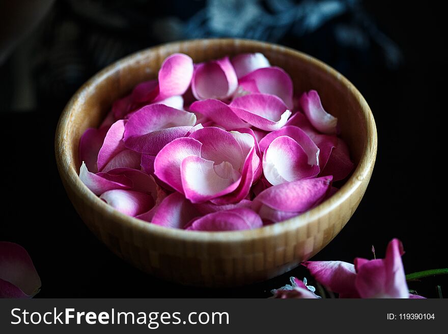 Close-up macro photo of rose petals in a wooden bowl