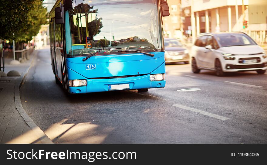 Bus moving on the road in city in early morning. View to the traffic with trafficlights and transport