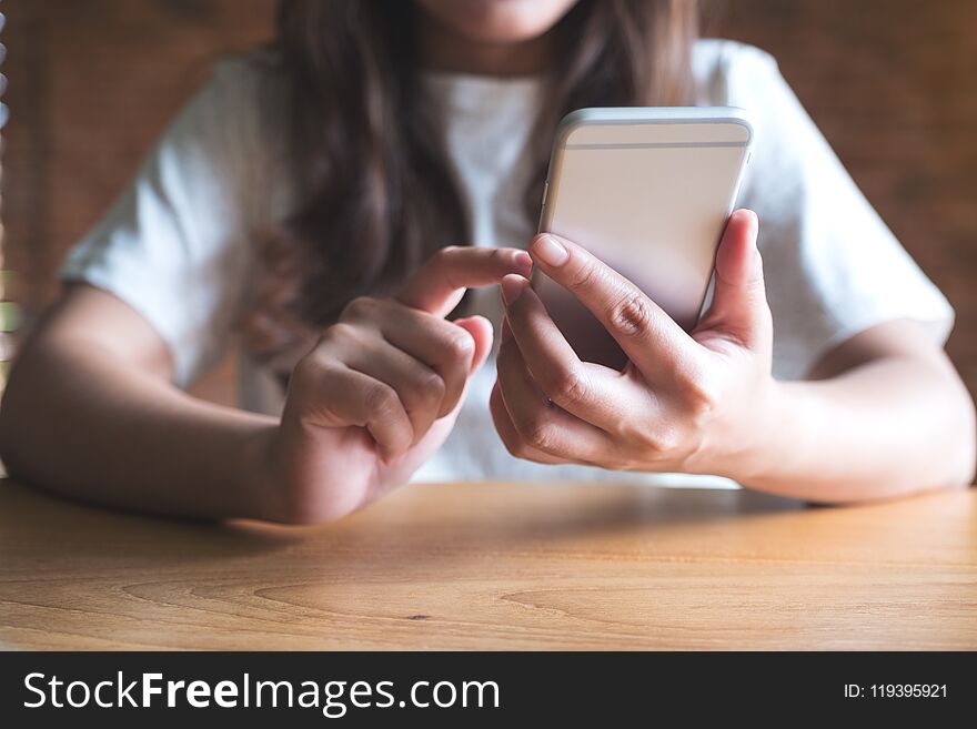 A Woman Holding , Using And Touching A Smart Phone While Drinking Coffee