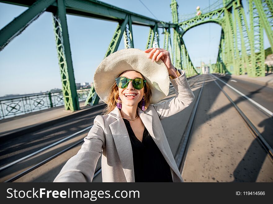 Young woman tourist making selfie photo on the Liberty bridge traveling in Budapest city, Hungary. Young woman tourist making selfie photo on the Liberty bridge traveling in Budapest city, Hungary