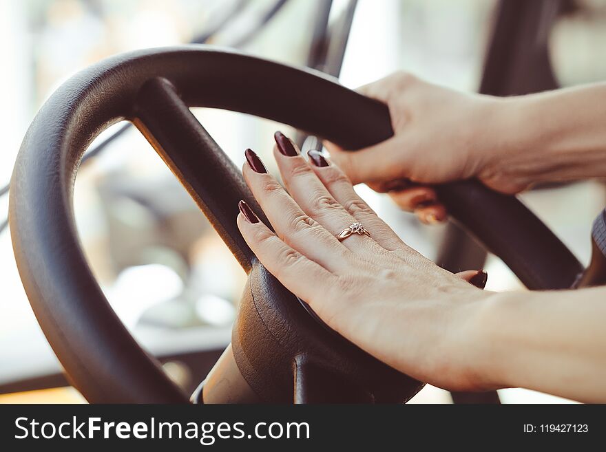 Women`s hand holding the steering wheel of a truck. Women`s hand holding the steering wheel of a truck