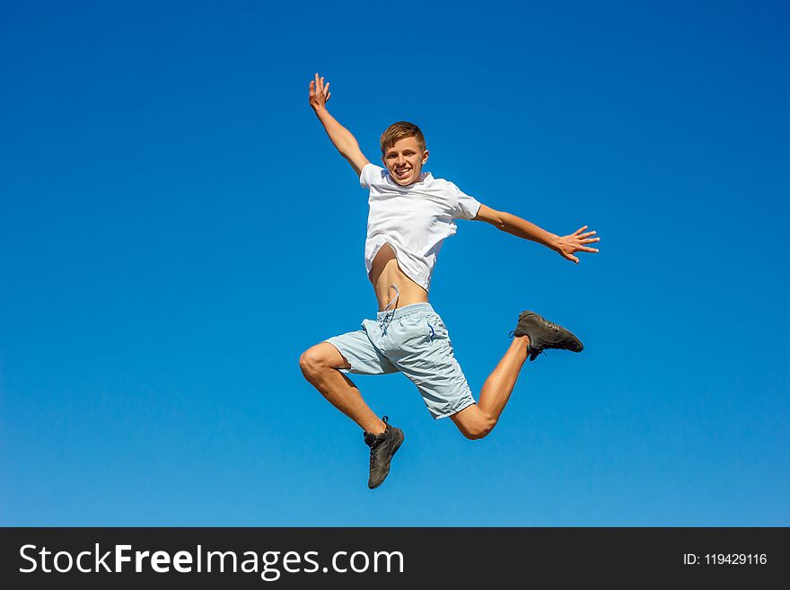 Happy boy jumping in the blue sky , concept of happiness/