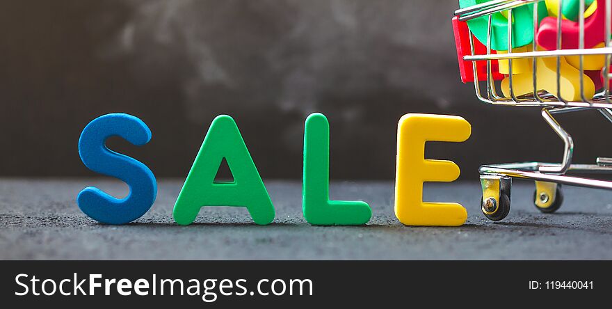 Sale, discount, black Friday concept with bright inscription Sale on a dark background, consumer trolley with letters. Banner