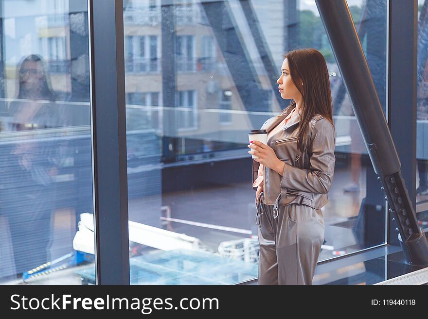 Young Asian Woman With Cup Standing Against Window.