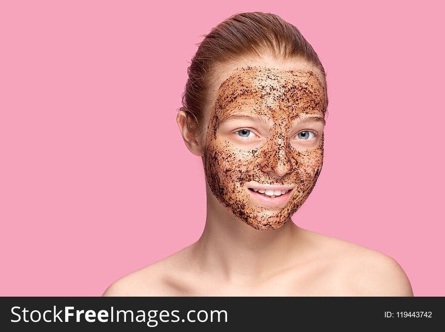 Face Skin Scrub. Portrait Of Smiling Female Model Applying Natural Coffee Mask, Face Scrub On Facial Skin. Closeup
