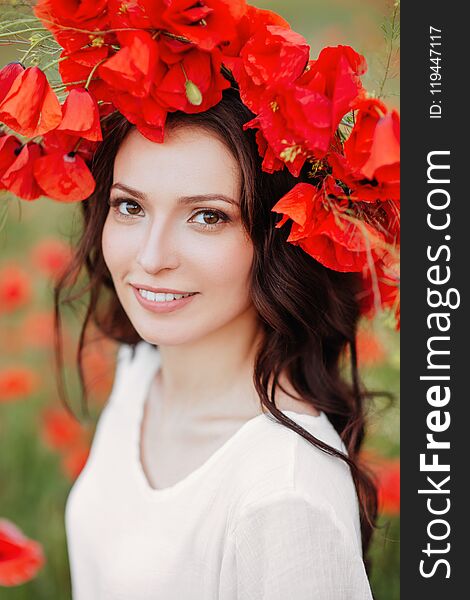 Beautiful girl in red poppy field