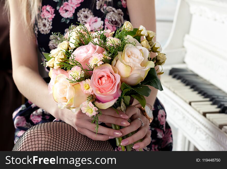 Woman holding a gorgeous flower bouquet in pink tones decorated with a bow for Valentine s day and for the bride.