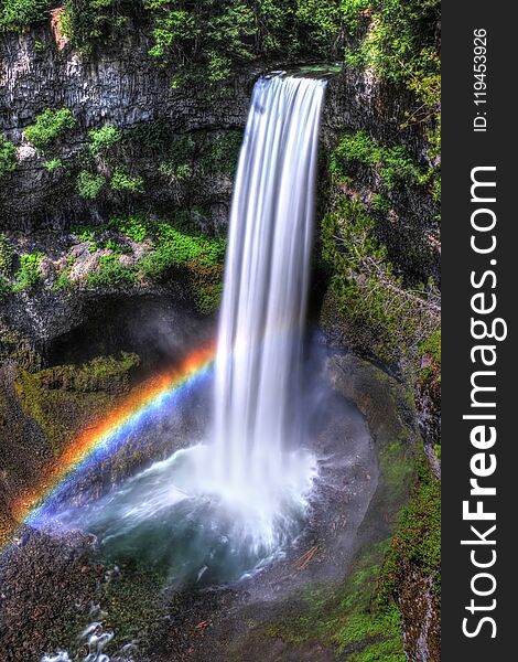 Rainbow Over Waterfalls In Sunny Day.