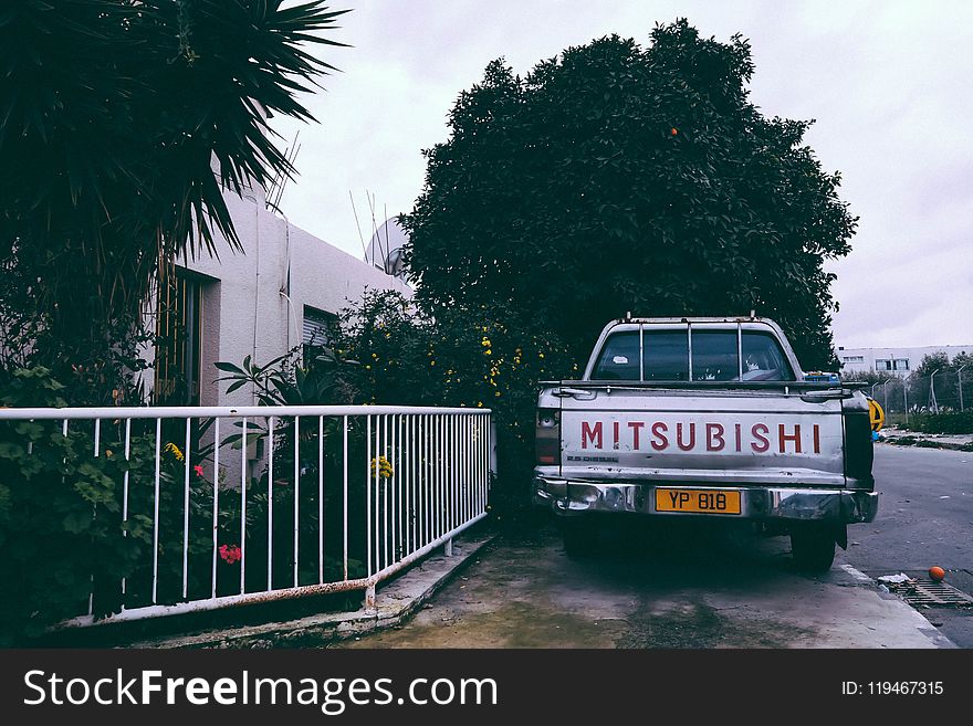 Gray Mitsubishi Car Parking Near White Hand Rails