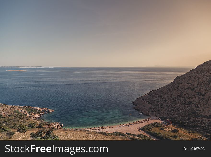 Body of Water Beside Mountain