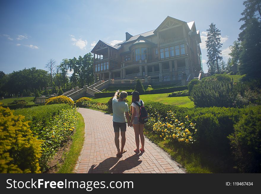 Photo of Couple Standing Outside the House
