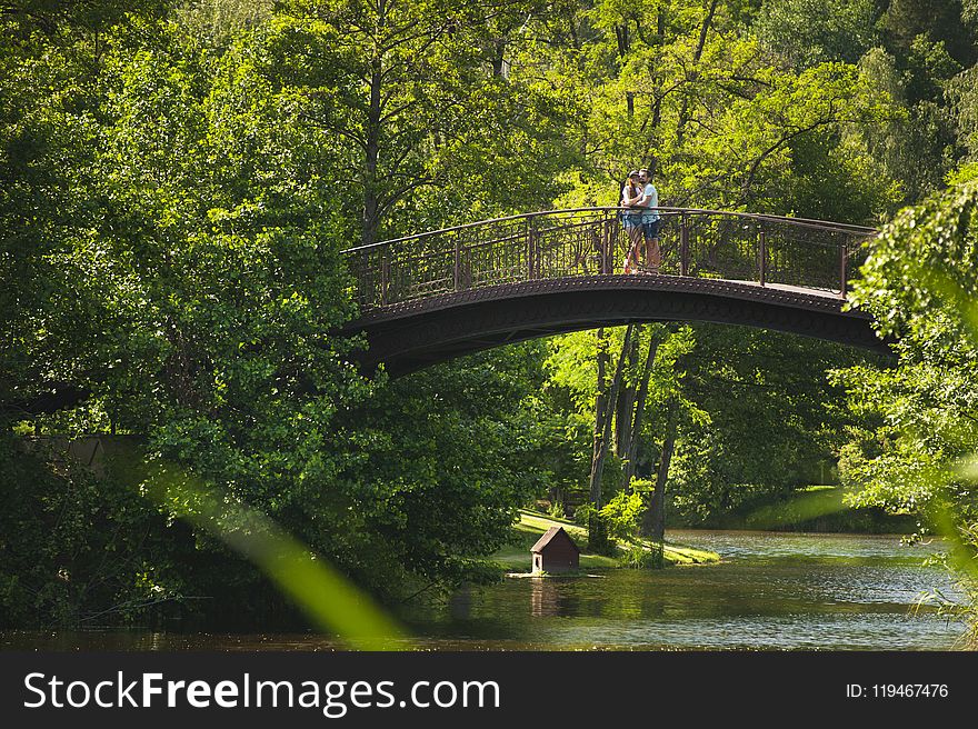 Photo of Couple Hugging on Bridge over River