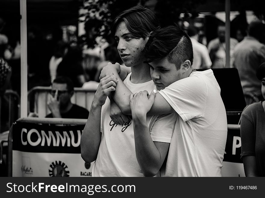 Grayscale Photography of Man Hugging Each Other