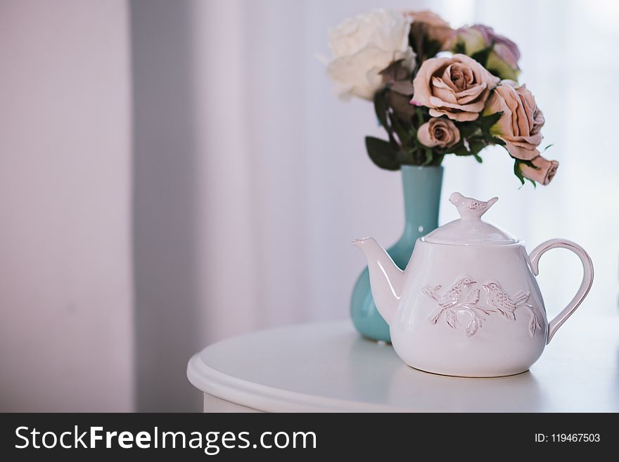 White Ceramic Teapot Near Flower Arrangement on White Surface