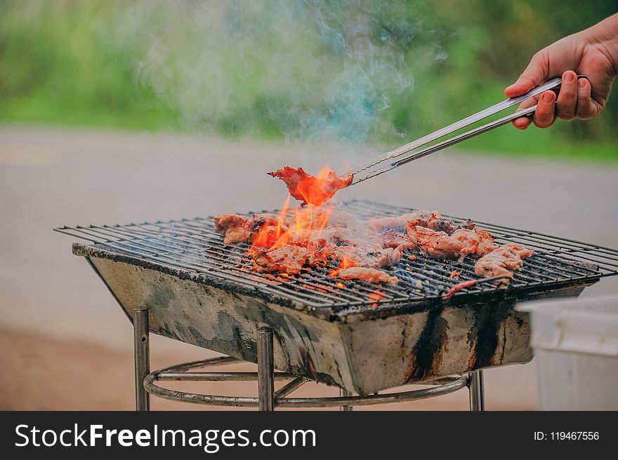 Person Holding Tongs Ccoking Barbecue