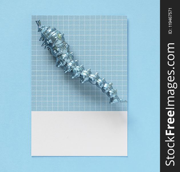 Photo of Caterpillar Figurine on Top of Blue and White Gingham Tile