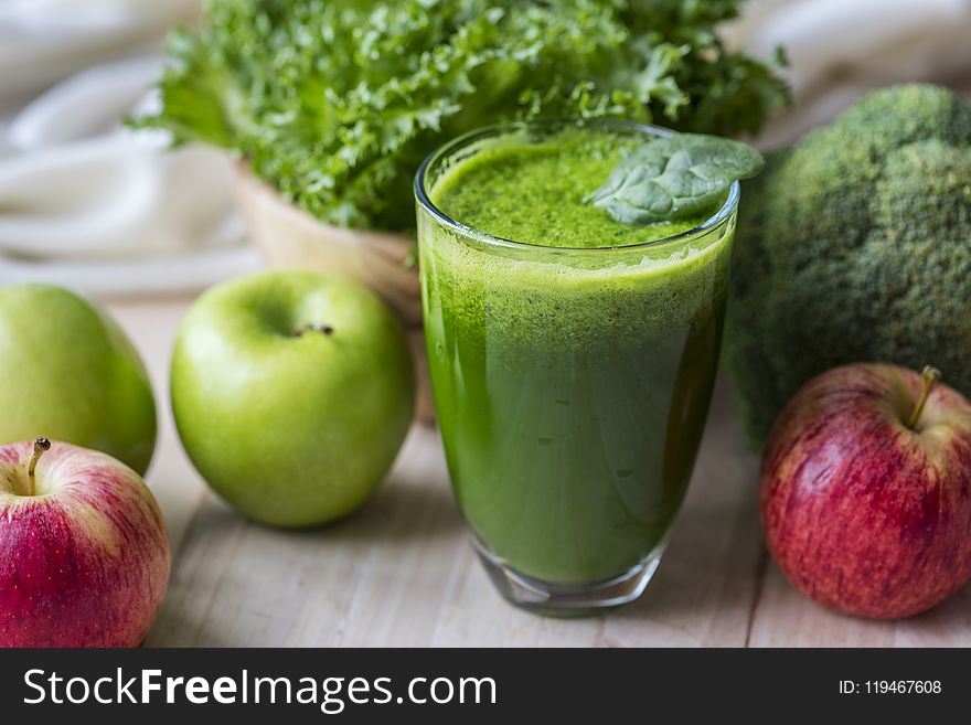 Green Liquid Fruit Juice on Glass Beside Apples