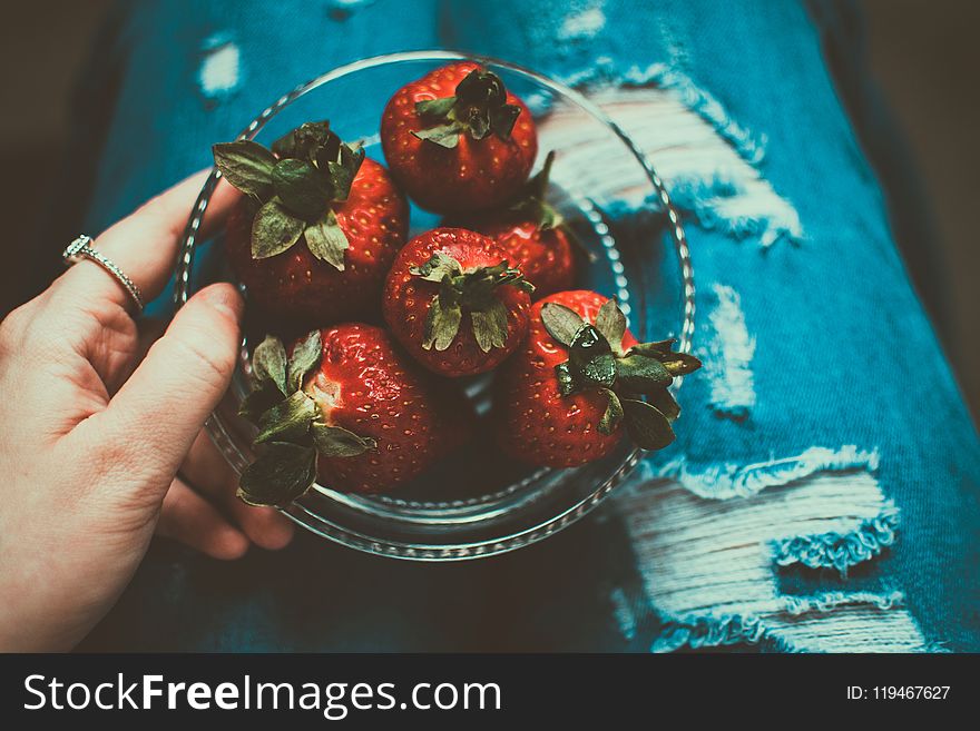 Person Holding Clear Glass Bowl of Strawberries
