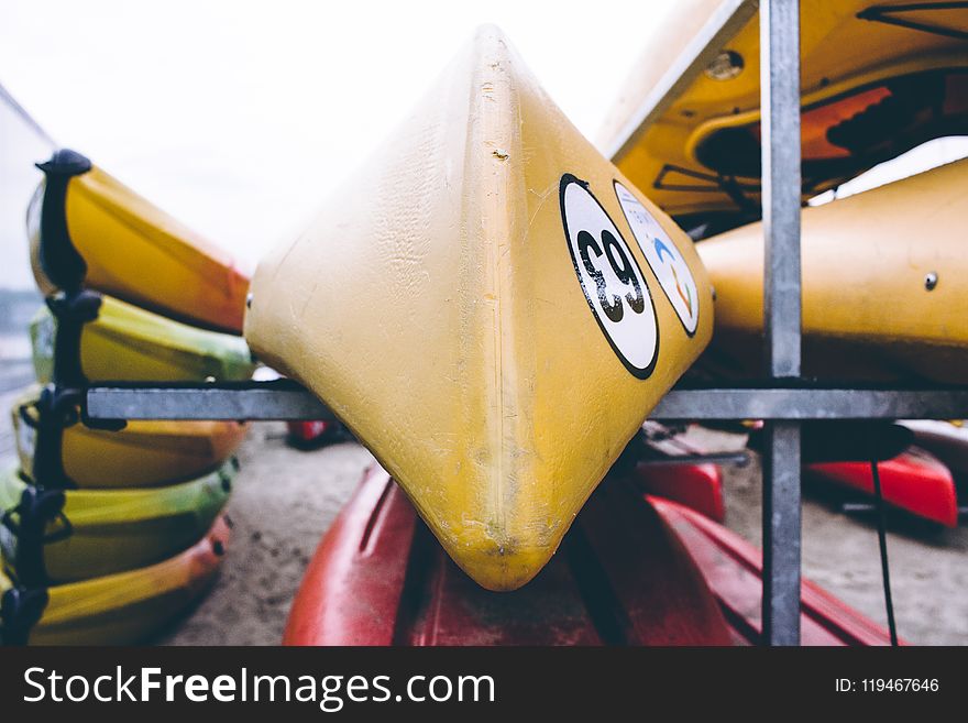 Closeup Photo of Yellow Kayak on Gray Metal Rack