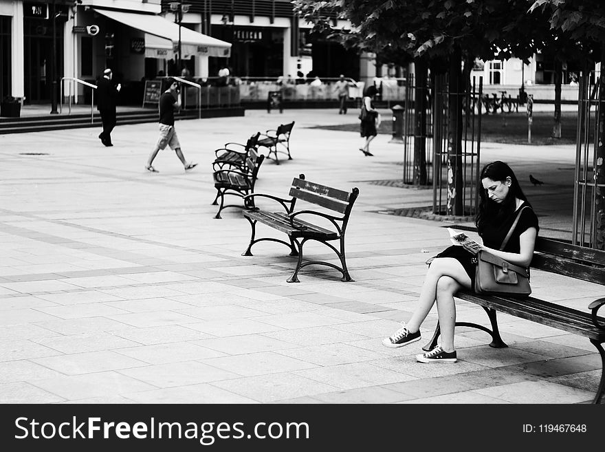 Grayscale Photography of Woman Sitting While Reading Book