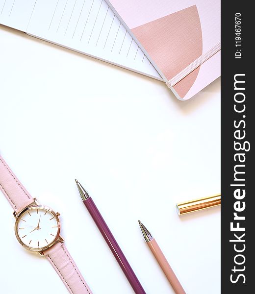 Flat lay Photography of Watch Near Pens and Notebook