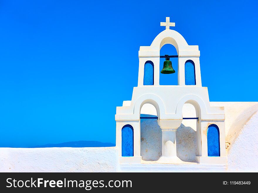 Small white bell-tower in Oia town in Santorini against blue sky, Greece. Small white bell-tower in Oia town in Santorini against blue sky, Greece