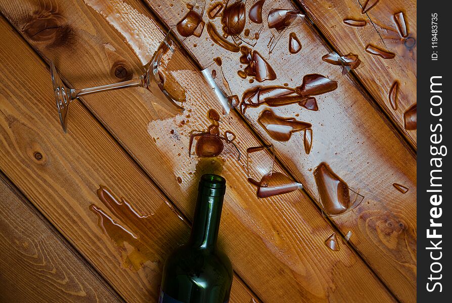 Broken wine glass with bottle on table