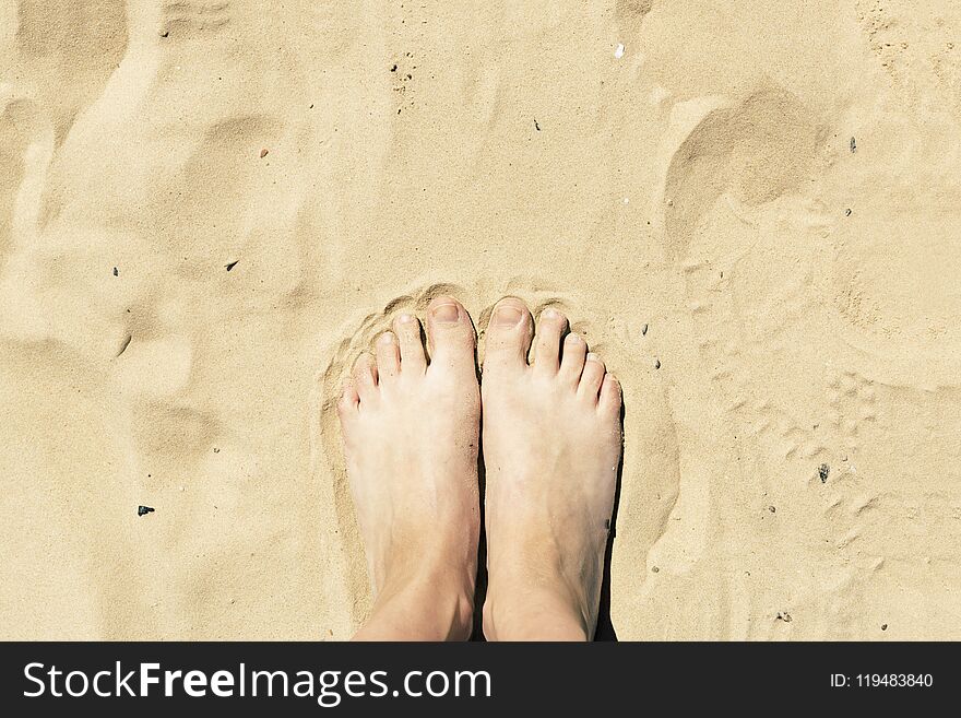 Feet in the sand. Summer vacation concept. Yellow beach sand