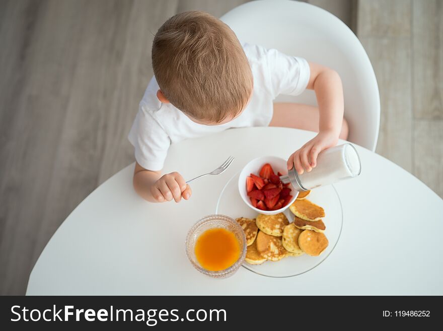 The child has Breakfast on a Sunny morning