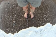 Feet Of The Man In The Foam Of A Sea Wave Stock Image