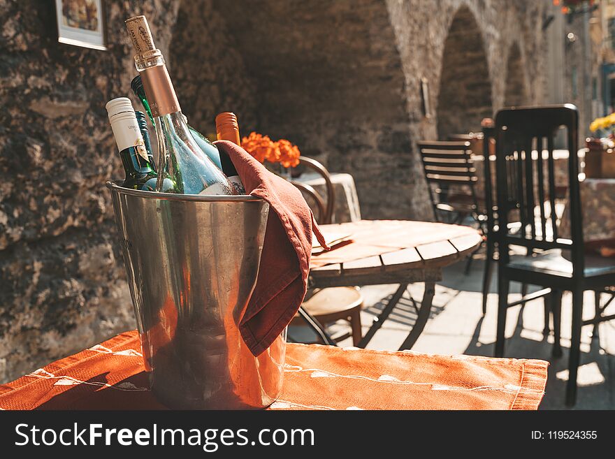 June 11, 2018. Open street restaurant on the streets of Tallinn in Estonia. Cozy chairs and tables standing in the old town with a champagne bottle on a table.