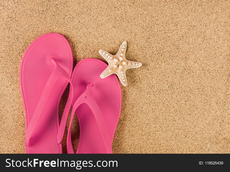 Pink sandal flip flop on sand beach and starfish