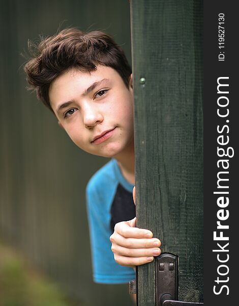 Teenager boy happy summer outdoor close up portrait on green fence background