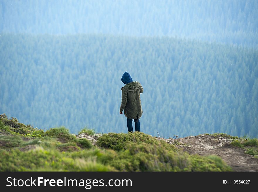 Person In Green Jacket Standing On Cliff