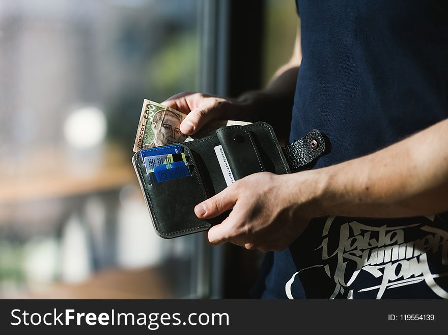 Photograph of Person Holding Black Leather Wallet with Money