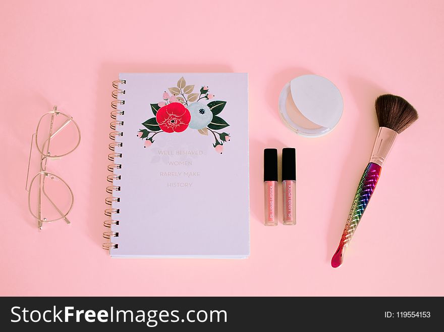 Flat lay Photography of Notebook Near Eyeglasses and Make-up