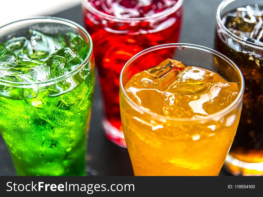 Four Clear Drinking Glasses Filled With Beverages