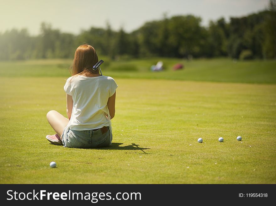 Photo Of Woman Sitting On Grass Field