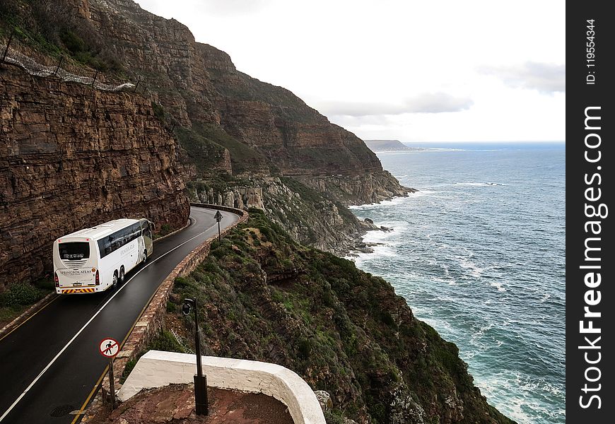 White Bus on Road Near Cliff